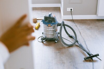 Aspirateur et balais sur un sol en parquet