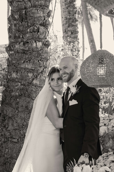 Black and white photo of bride and groom holding each other during Arizona resort wedding.