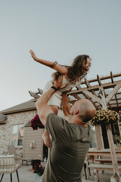 dad hoisting kid in air