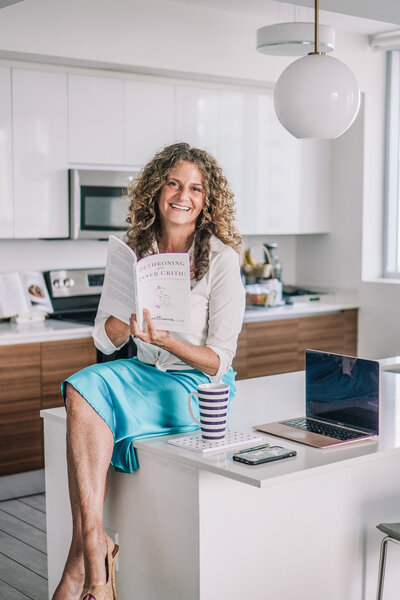 Woman sitting on counter with book