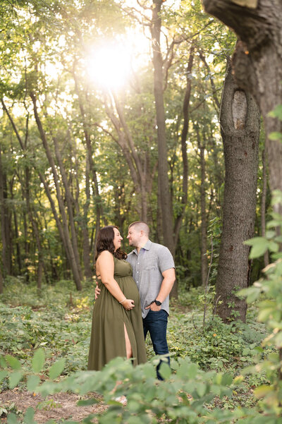 Husband and wife walking and holding hands with mom-to-be's hand on her baby bump