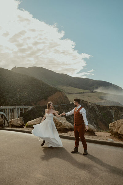 Bride twirling groom on top of Taft Point in Yosemite at sunset with view of El Capitan