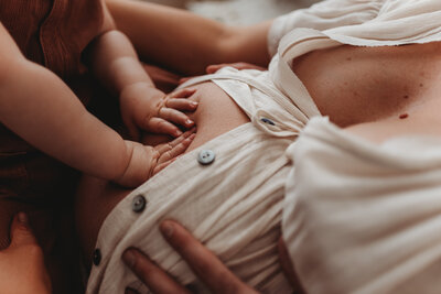 baby's hands on mother's pregnant maternity belly