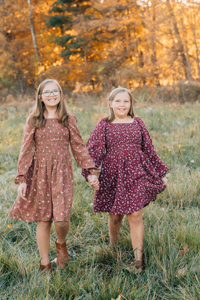 Sisters walking together surrounded by fall colors.