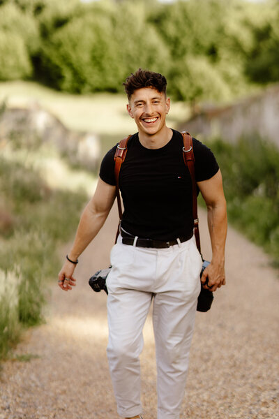 Ollie Baines with camera in hand at outdoor photoshoot