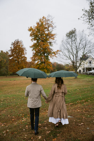 Engagement session in Hudson Valley featuring a couple walking hand in hand in fall scenery