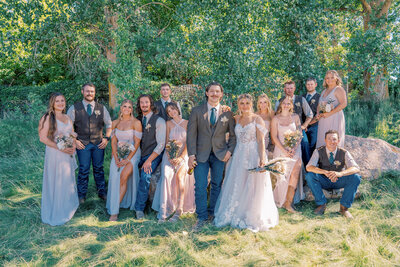 Full wedding party posing outdoors in natural light, featuring the bride, groom, bridesmaids, and groomsmen in coordinated attire, captured by Joseph Mayden Photography.