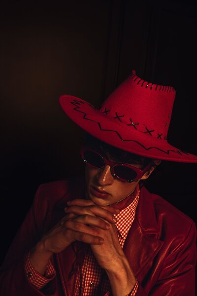 in deep thought, red cowboy hat, red sunglasses, plaid red and white shirt