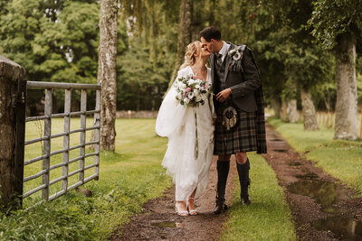 Bride and Groom kissing under neaon sign at alternative scotland wedding