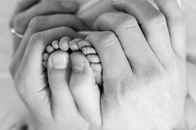 Parents holding baby's feet in a heart