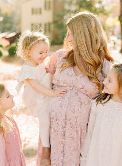 Toddler sitting on mom's belly during a Raleigh maternity photography session. Image by Raleigh family, maternity & newborn photographer A.J. Dunlap Photography.