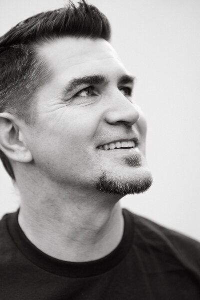 A male kalispell denture studio patient smiling to one side and showing his new teeth