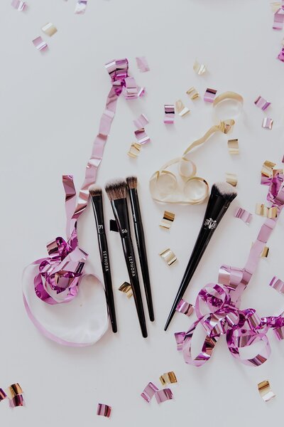 Black makeup brushes detail with purple and cream confetti