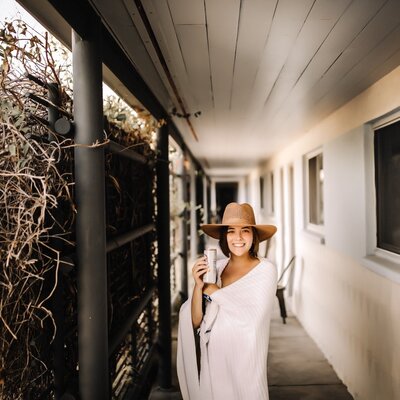 Katie Denton Photography - woman posing on a porch with a drink in her hand