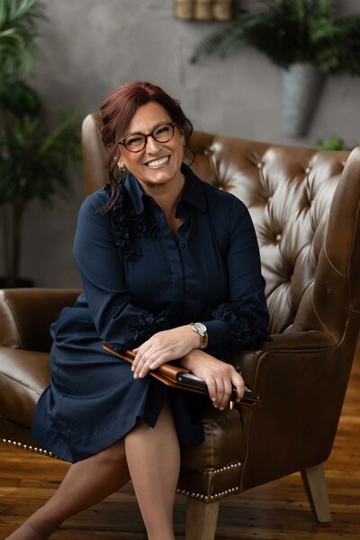 woman in a formal attire sitting on the brown couch