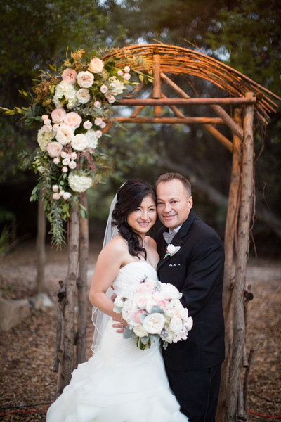 Bride and Groom standing in their ceremony arch at Temecula Creek Inn