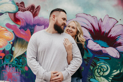couple in front of colorful mural