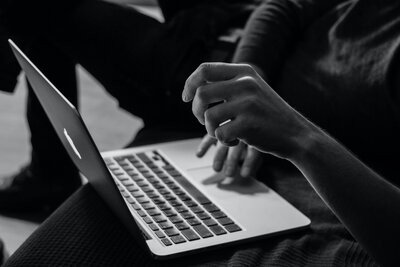 black and white photo of someone navigating on laptop