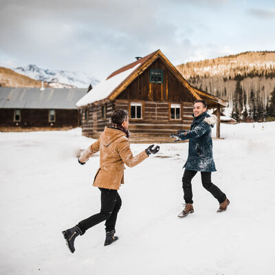 A couple has a snowball fight.