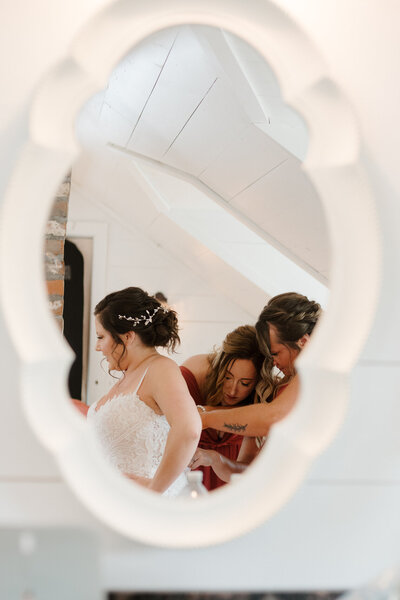 Bridemaids helping bride get into her dress