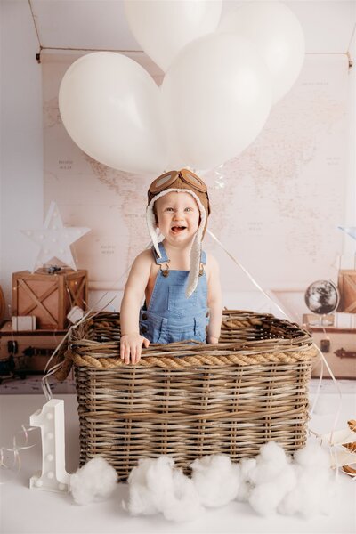 Theo standing in a hot air balloon basket during his photoshoot with cakesmash auckland photographer michelle kelly
