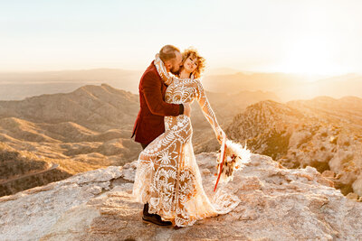 Saguaro National Park engagement photo shoot couple standing in desert at sunset with cacti.