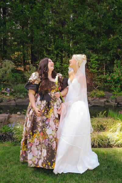 Clarae and Taressa, besties and wedding planners in Oregon, smile and laugh together at Clarae's wedding. 