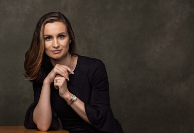 Modern Luxury Portrait of woman leaning on table with arms folded