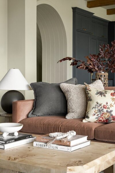 A cozy living room featuring a comfortable couch, a stylish coffee table, and a warm lamp illuminating the space.