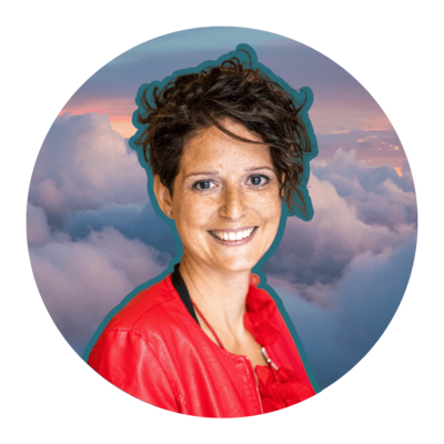 Short haired woman smiling at the camera with clouds in the background