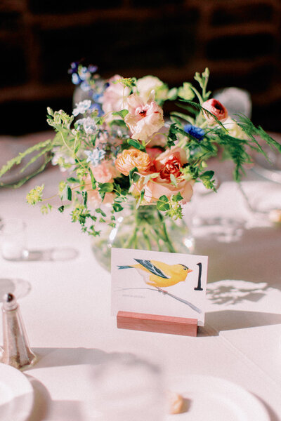 A floral arrangement in the middle of a wedding reception table 