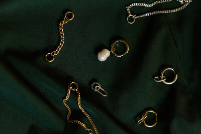 High-quality, eco-friendly jewelry for conscious consumers laid out on a green backdrop.