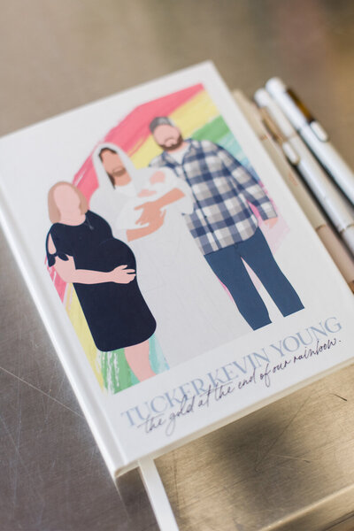 Custom illustrated guest book for a woodland-themed baby boy shower, featuring a cover illustration of the parents-to-be with Christ holding their lost baby.