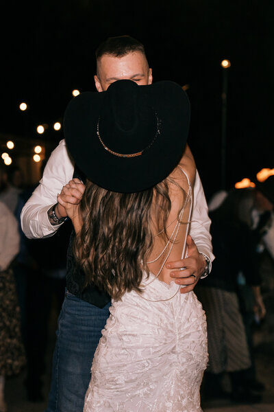 Western wedding ceremony moment with bride and groom pouring soil together at a rustic outdoor ranch wedding