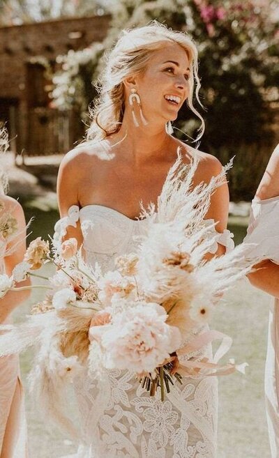 bride holding a large white flower bouquet