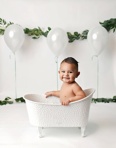 Cute kiddo posing in bathtub at Denver Cake Smash