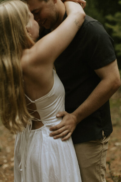 An intimate photo of a couple embracing each other captured in a forest in Holland, Michigan.