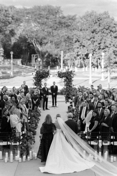 Chicago wedding photos of Bride standing in rain with umbrella in a vintage wedding gown with white lace umbrella taken by Allison Francois Photography