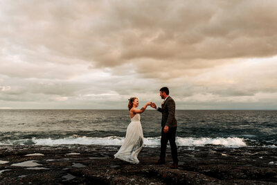 married couple dancing on the shores of Lake Superior in Gooseberry State Park