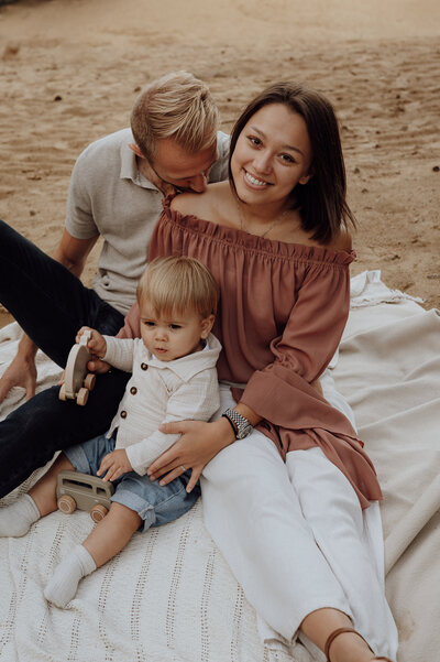 Gezin speelt op dekentje tijdens familie fotoshoot  op Landschotse Heide in Beerzel, Antwerpen