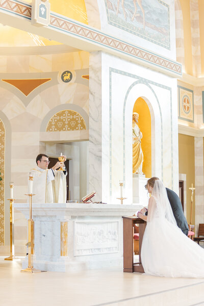 a couple participating in a Catholic wedding ceremony
