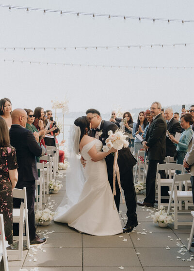 Couple kissing down the aisle at Hyatt Lake Washington rooftop ceremony