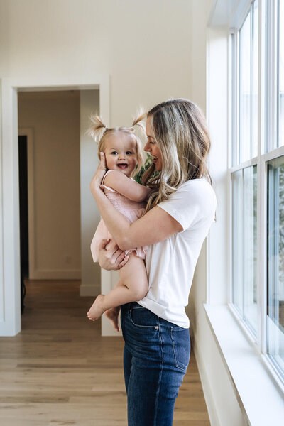 Wellness coach and toddler mom smiling together—real-life wellness support for moms in early motherhood.