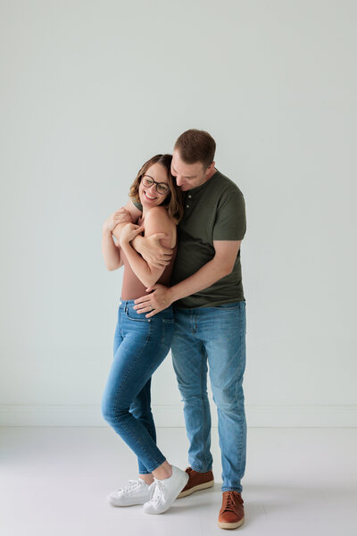 Dad tosses his little girl while mom snuggles her newborn baby brother