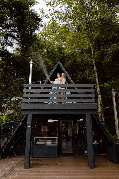 Eloping couple popping champagne at their Airbnb.