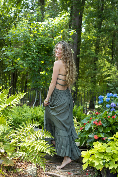 Dr. Mamie Burruss smiling and walking outside surrounded by plants