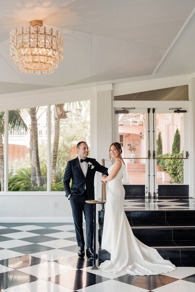 Bride and Groom standing on staircase with long dress at La Valencia wedding venue