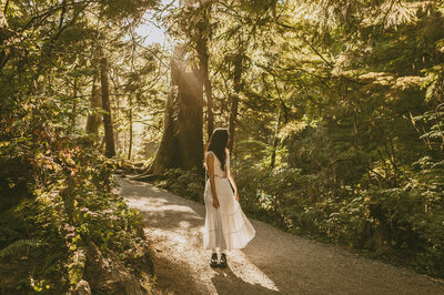 Girl walking through forest on dirt path
