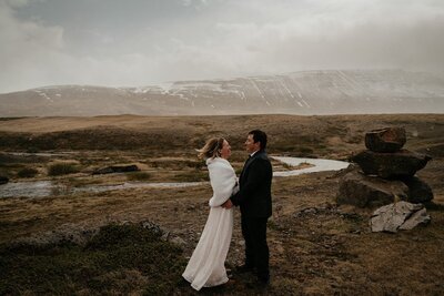 Bride and groom stand facing each other during their wintery Iceland elopement. 