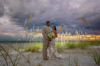 Bride and groom backlit on the beach at sunset by Sarasota photographer, Love and Style Photography